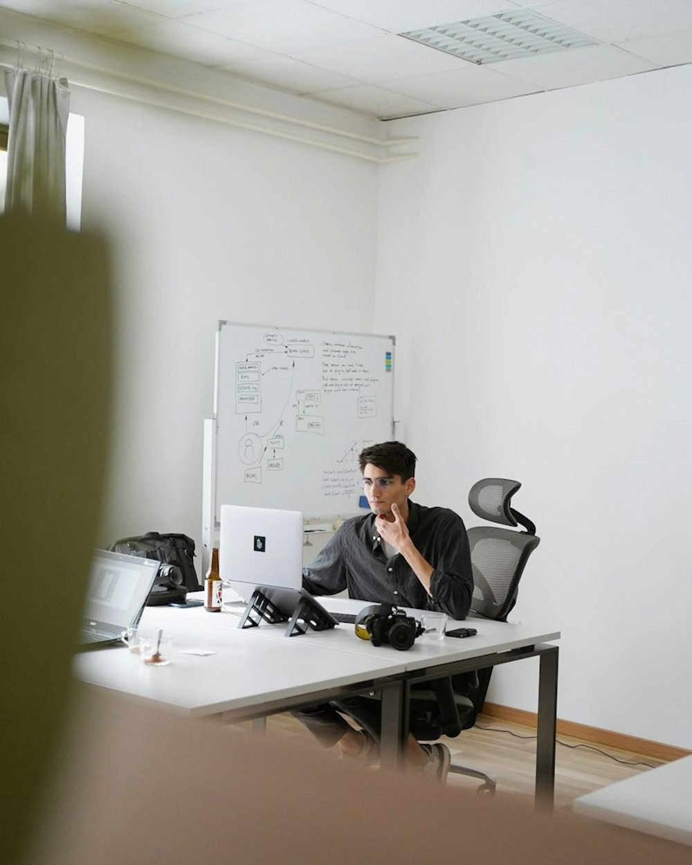 Professional sitting in a black ergonomic office chair at a modern desk workstation